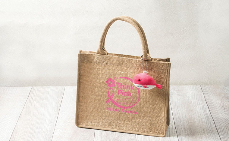 『オリジナルロゴ付き特製バッグ（ピンクリボン活動限定版）』（2,000円）と『ピンククジラマスコット』<br />
写真提供：ヒルトン沖縄瀬底リゾート<br />
