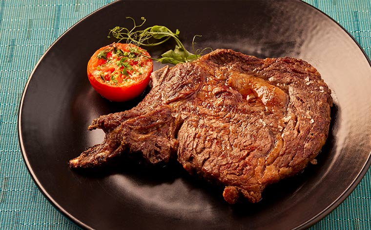 アンガス牛 骨付きリブアイ デルモニコステーキ $79<br />
写真提供：ヒルトン・ハワイアン・ビレッジ・ワイキキ・ビーチ・リゾート